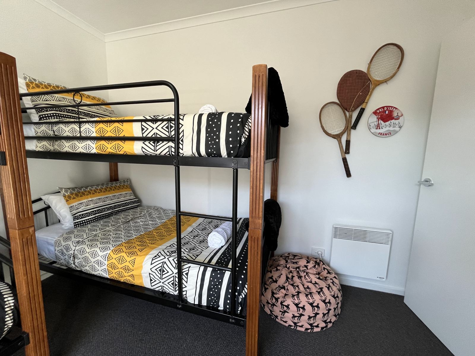 Bunk room with two sets of bunks and vintage tennis rackets