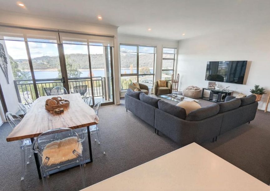 Living room with sectional sofa and windows over Lake Jindabyne